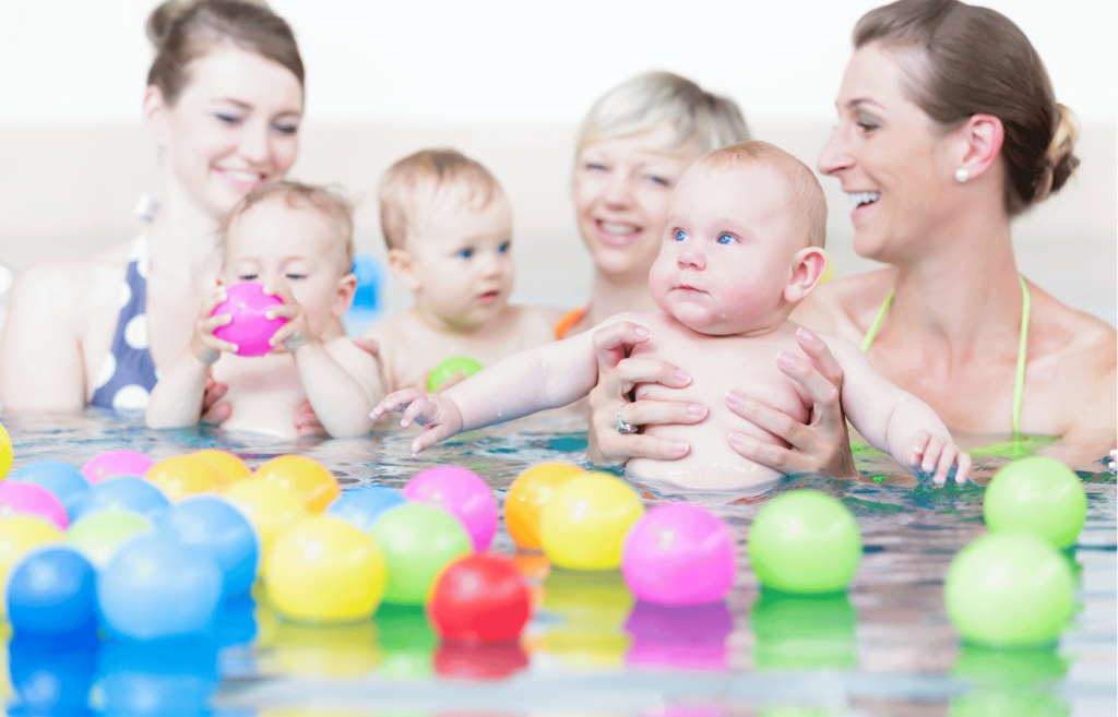 Kinder spielen mit Bällen beim Babyschwimmen