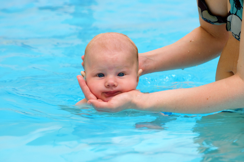 Mutter hält Kind im Wasser mit einem Haltegriff