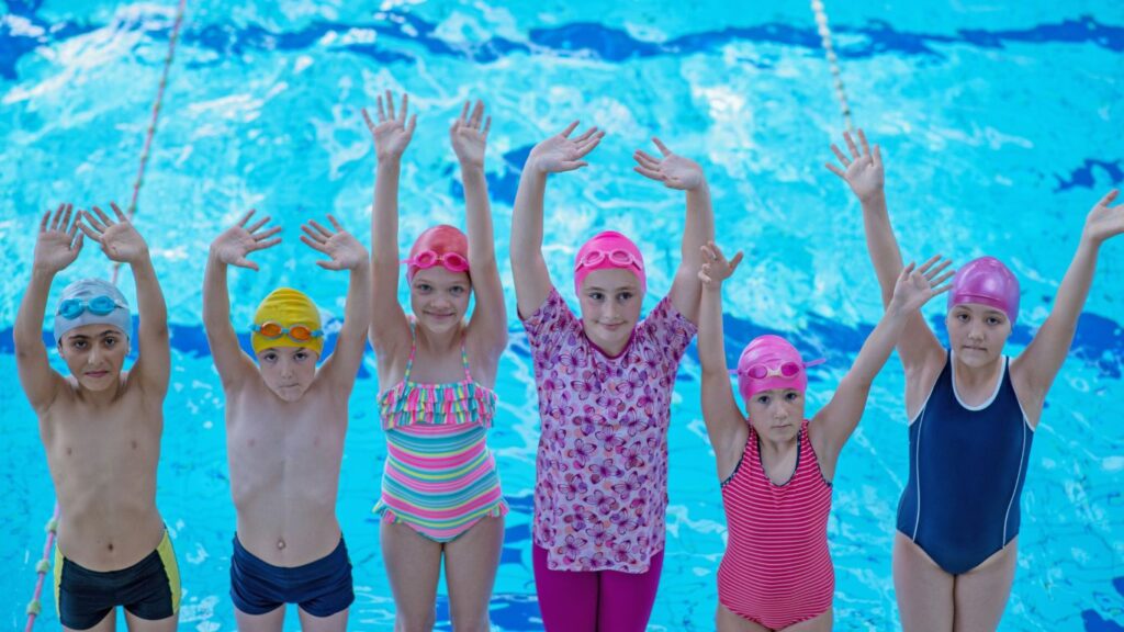 Kinder feiern die bestandene Schwimmprüfung.